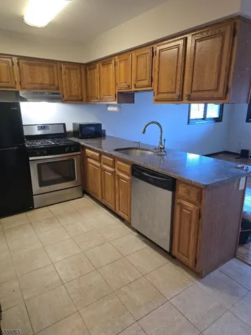a kitchen with stainless steel appliances granite countertop a sink stove and cabinets