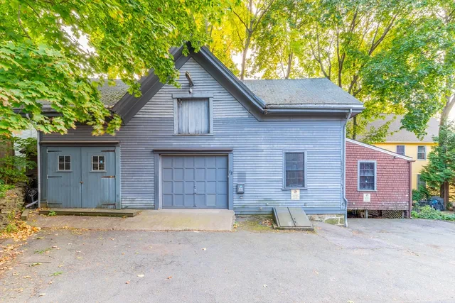a view of a house with a yard and large tree
