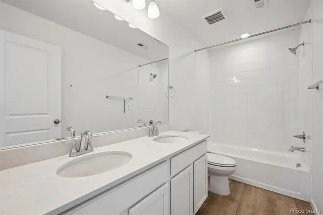 a bathroom with a sink double vanity granite toilet tub and shower