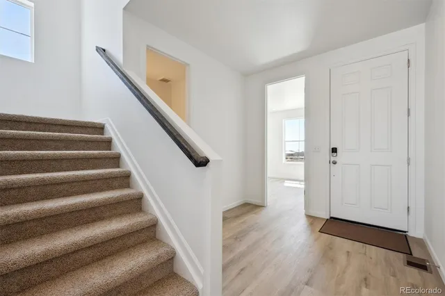 a view of entryway with wooden floor and stairs