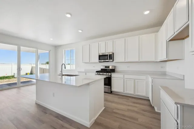 a kitchen with white cabinets and appliances