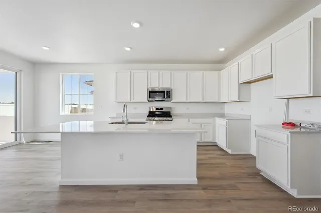 a kitchen with granite countertop white cabinets and white appliances
