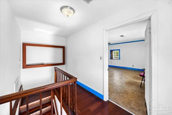 a view of a livingroom with wooden floor and stairs