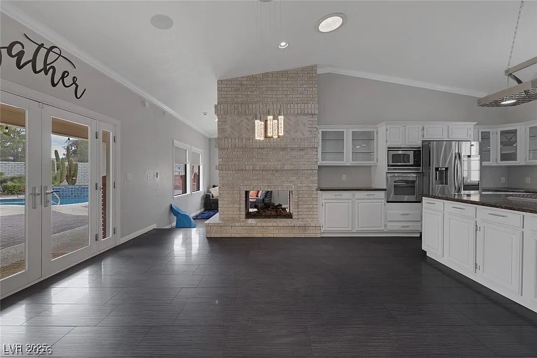 9 Quail Run Road Henderson, NV 89014 - Photo 16 of 57 A spacious great room offers seamless indoor-outdoor living with a cozy fireplace and modern kitchen access.