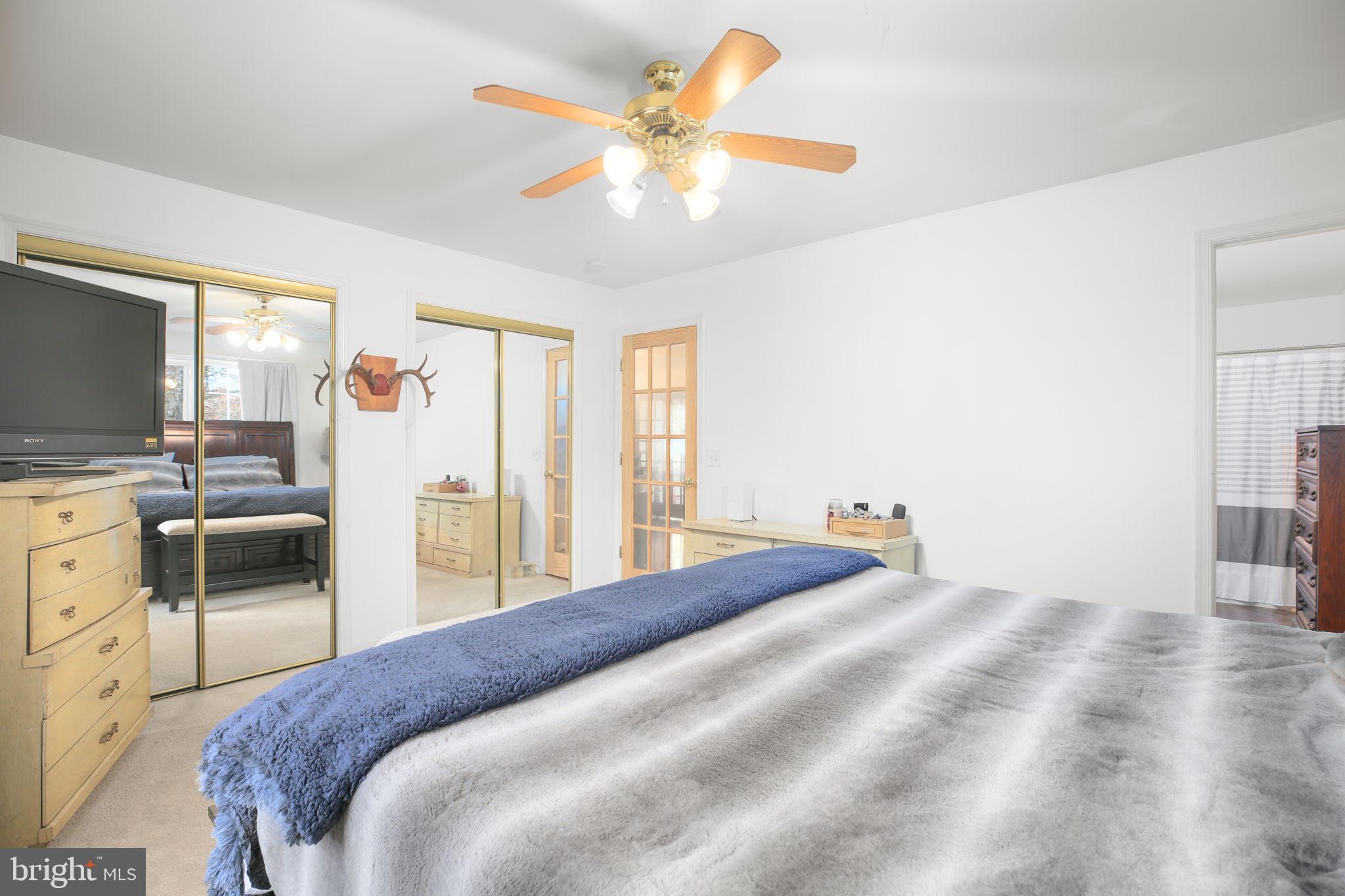 315 Sandy Ridge Road Fredericksburg, VA 22405 - Photo 17 of 42 a bedroom with a bed and a chandelier