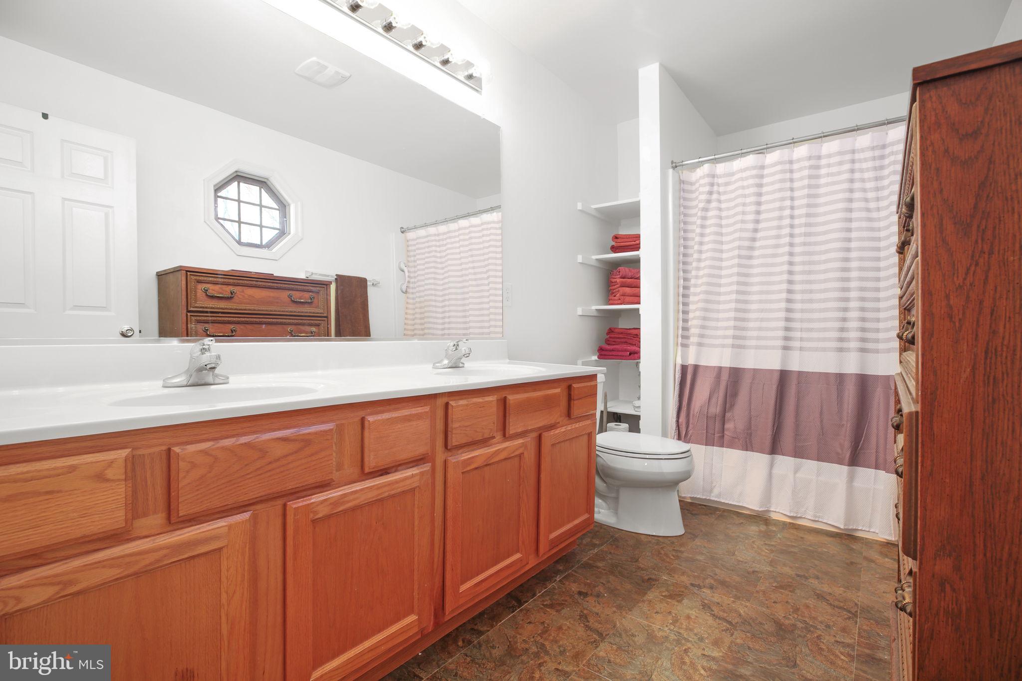 315 Sandy Ridge Road Fredericksburg, VA 22405 - Photo 18 of 42 a bathroom with a double vanity sink a toilet and a shower