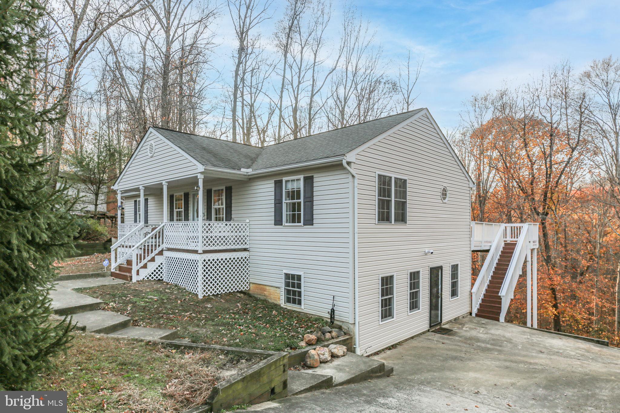 315 Sandy Ridge Road Fredericksburg, VA 22405 - Photo 3 of 42 a view of a white house next to a yard with road and trees