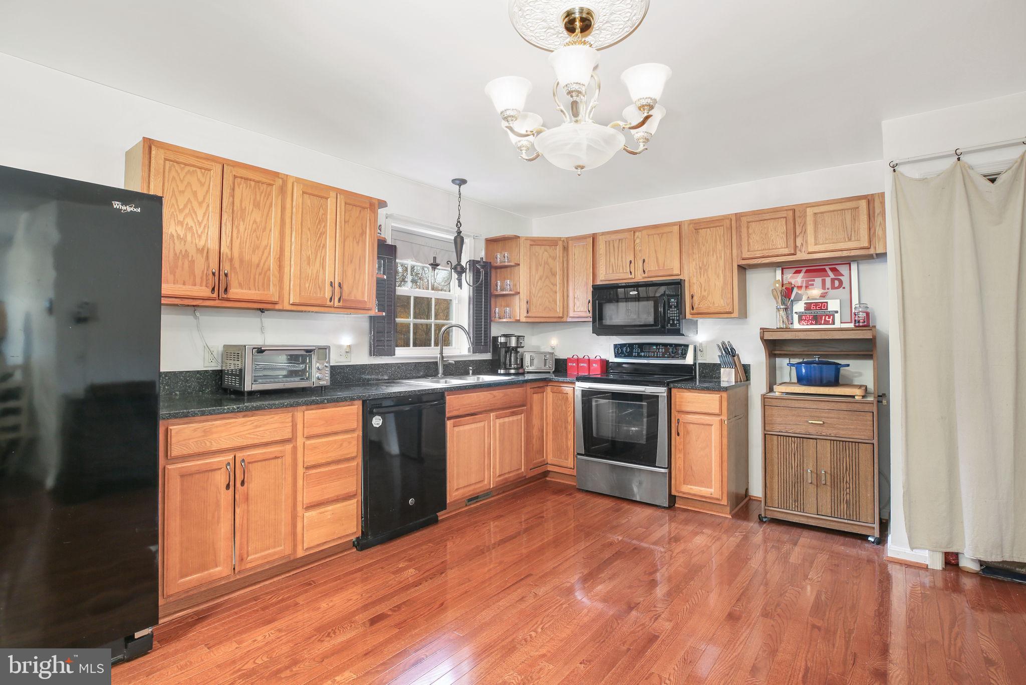 315 Sandy Ridge Road Fredericksburg, VA 22405 - Photo 5 of 42 a kitchen with stainless steel appliances granite countertop a refrigerator a stove top oven a sink and dishwasher with wooden floor