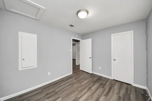 a view of an empty room with wooden floor