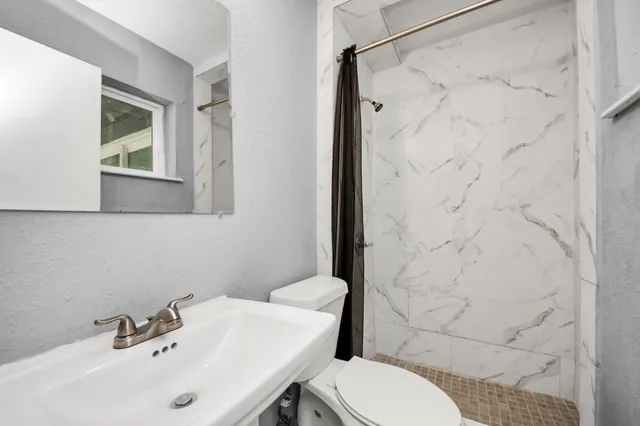 a bathroom with a sink toilet and shower