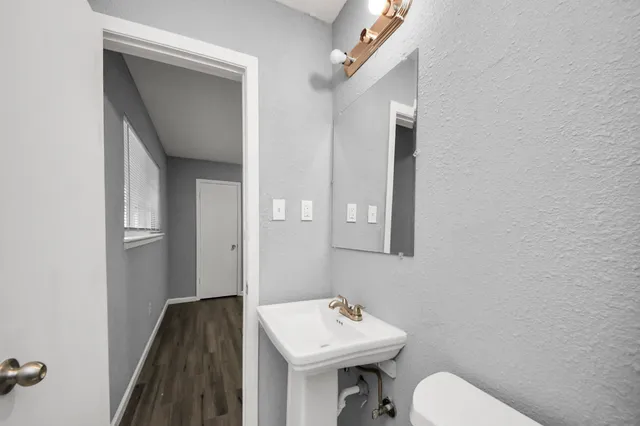a bathroom with a sink toilet and mirror