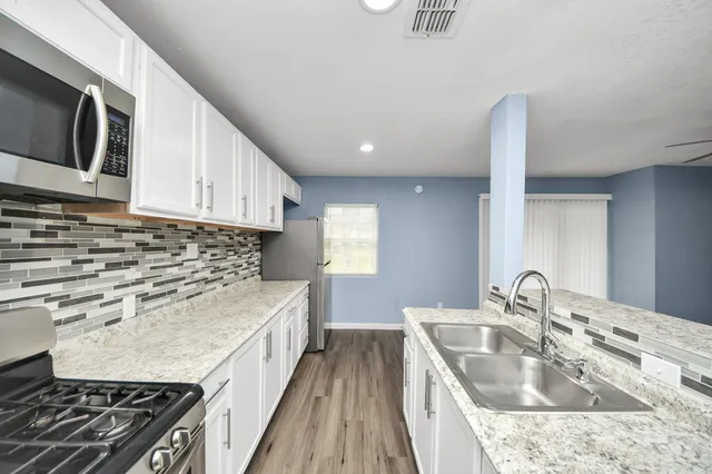 a kitchen with a sink stove and microwave