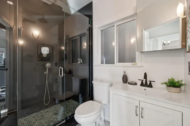 a bathroom with a sink a toilet and shower