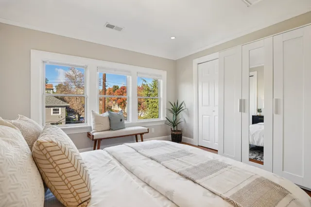 a bedroom with a large bed couch and a window