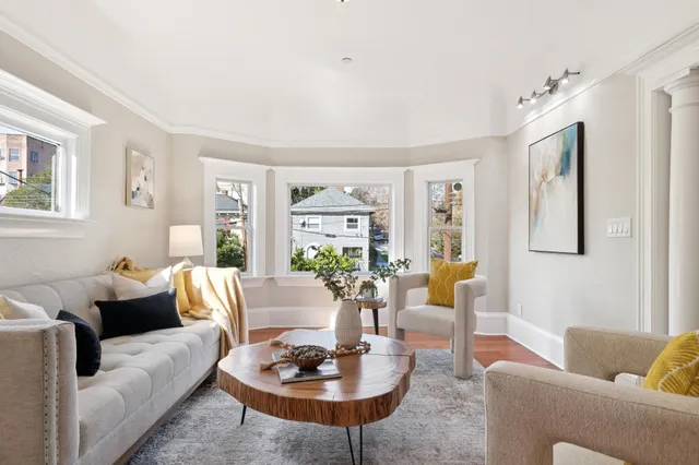 a living room with furniture kitchen view and a large window