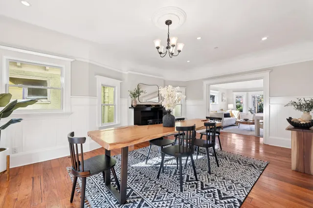 a view of a dining room with furniture a chandelier and wooden floor