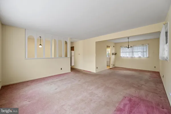 an empty room with windows and cabinet