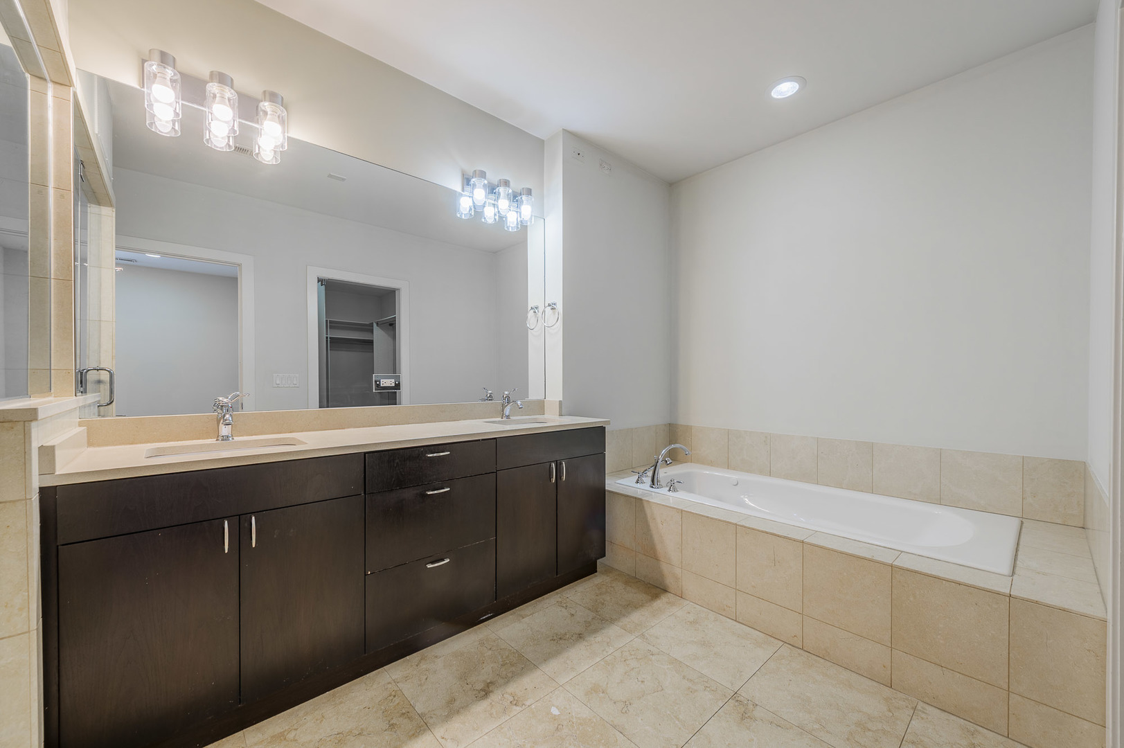 1162 West Hubbard Street, Unit 203 Chicago, IL 60642 - Photo 12 of 22 a spacious bathroom with a tub sink and mirror