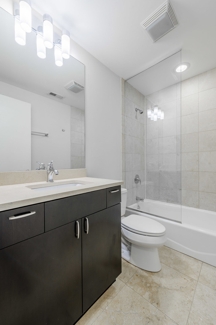 1162 West Hubbard Street, Unit 203 Chicago, IL 60642 - Photo 18 of 22 a bathroom with a sink a toilet and shower