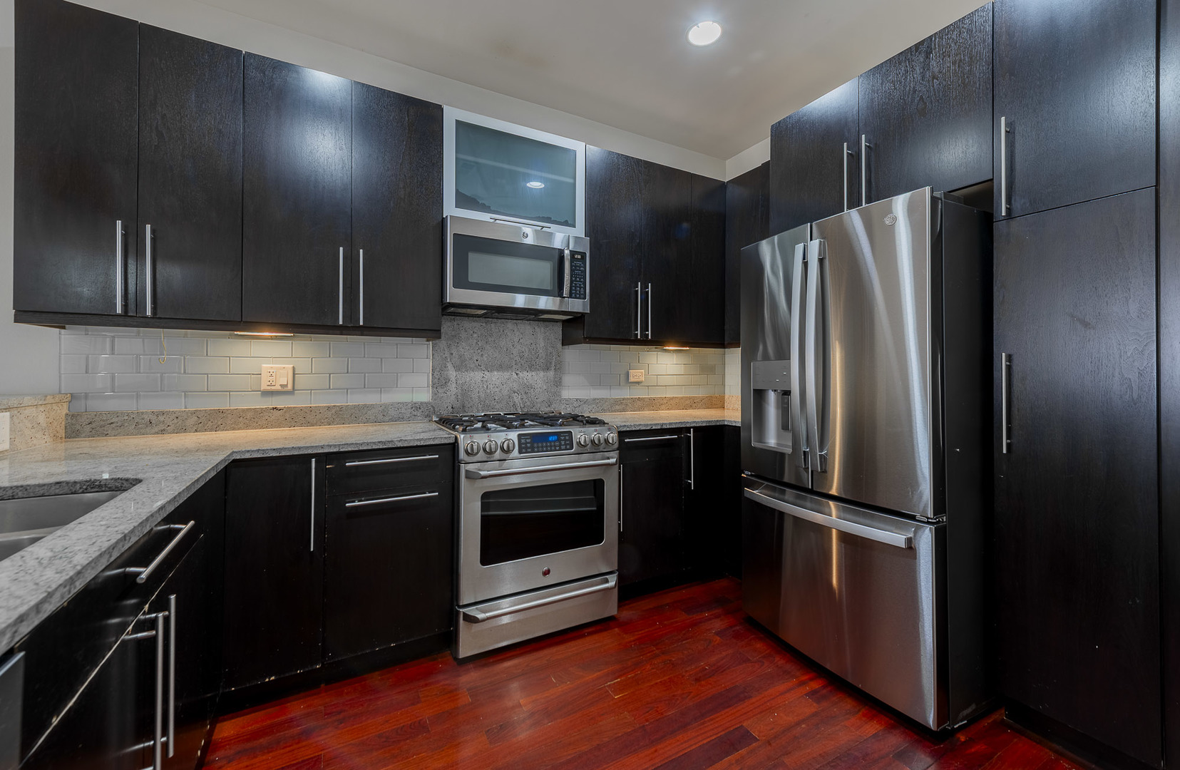 1162 West Hubbard Street, Unit 203 Chicago, IL 60642 - Photo 3 of 22 a kitchen with granite countertop stainless steel appliances and wooden cabinets