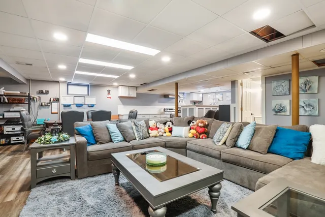 a living room with furniture kitchen view and a large window