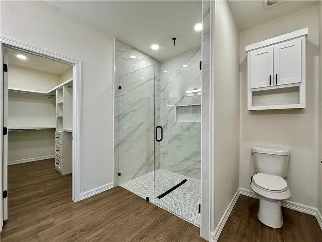 a bathroom with a shower a toilet and a sink