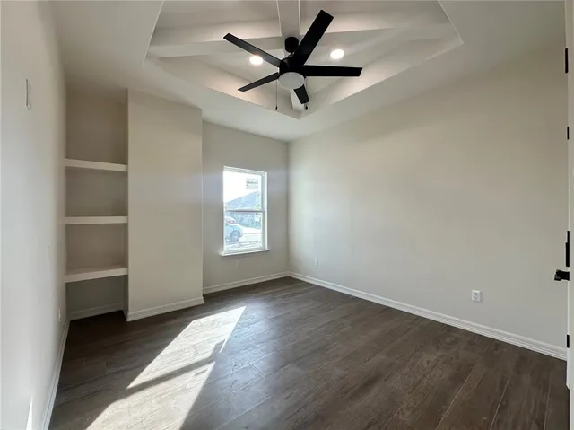 an empty room with windows and fan