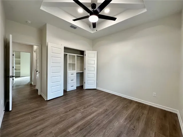 wooden floor in an empty room and a ceiling fan