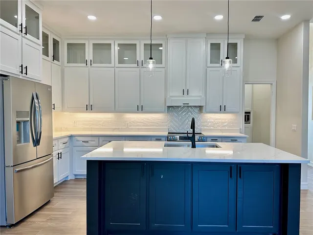 a kitchen with kitchen island granite countertop a sink stainless steel appliances and cabinets