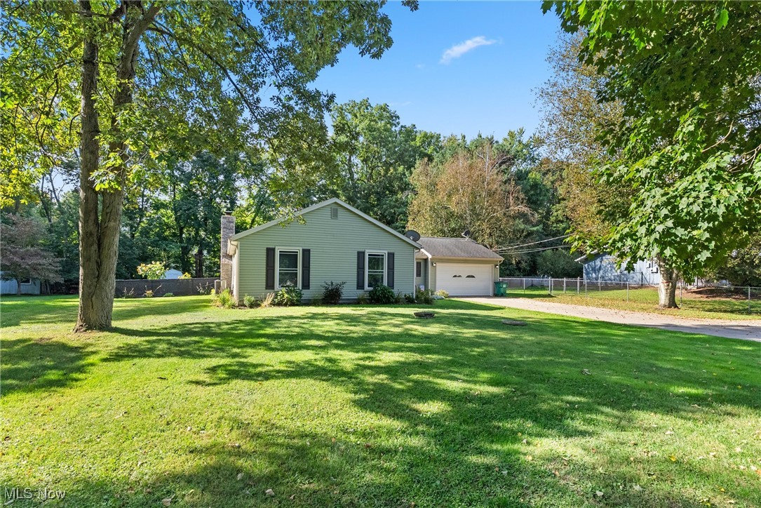 7944 Middle Ridge Road Madison, OH 44057 - Photo 2 of 31 Single story home featuring driveway, a chimney, a garage, and view of scattered trees