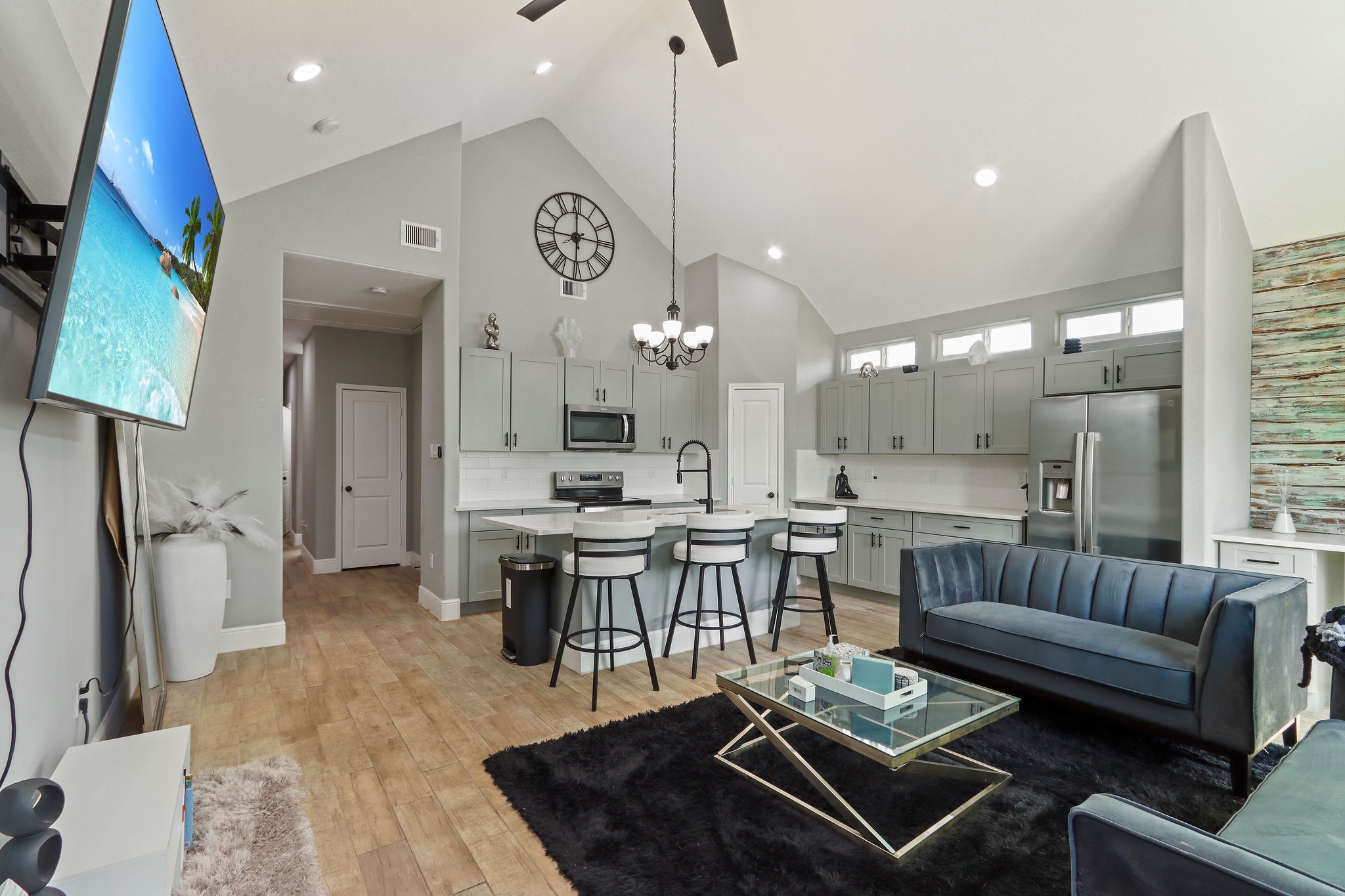 a living room with furniture a rug and kitchen view