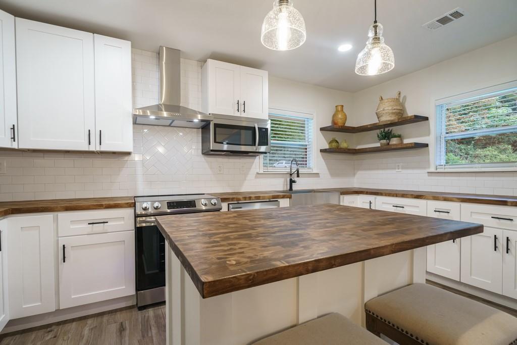 2359 Mark Trail Decatur, GA 30032 - Photo 6 of 35 a kitchen with kitchen island granite countertop a sink a center island cabinets and wooden floor