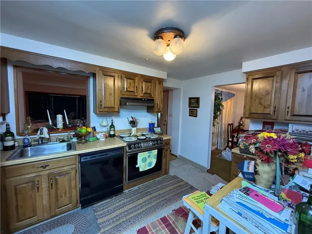 a view of kitchen with microwave stove dining table and chairs