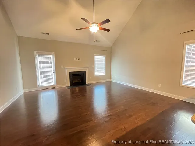 a view of a livingroom with a ceiling fan window and wooden floor