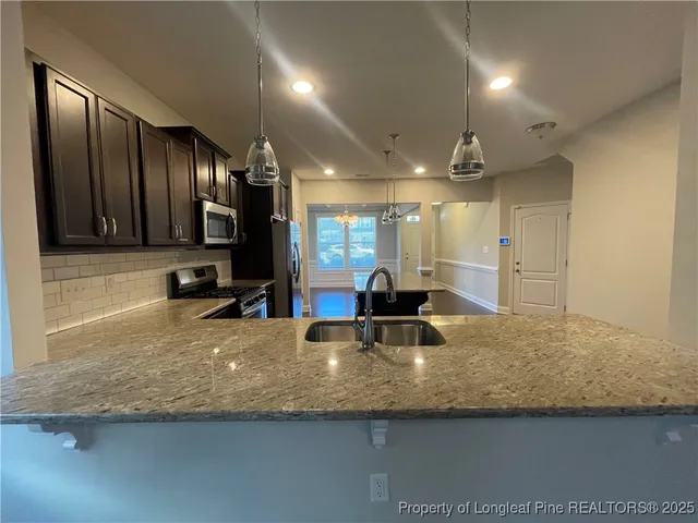 a view of a large kitchen with a center island and wooden cabinets
