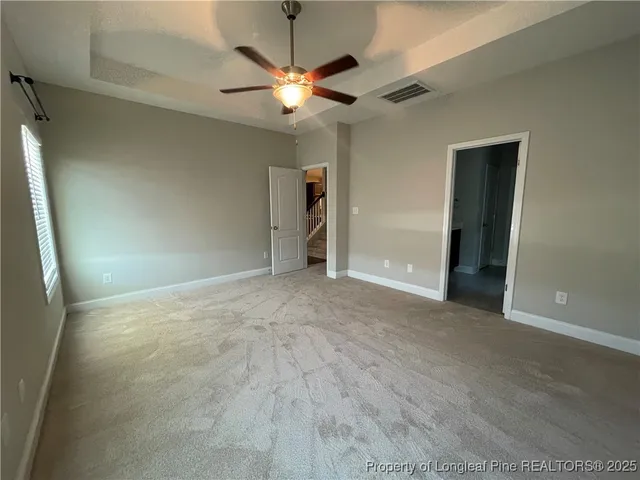 an empty room with fan and entrance
