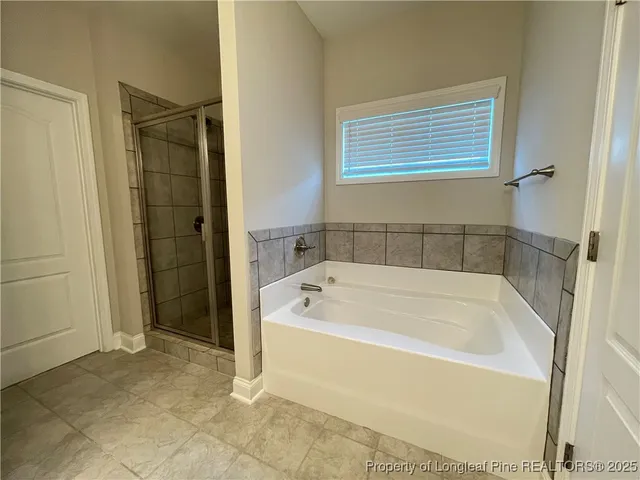 a white bath tub sitting next to a shower