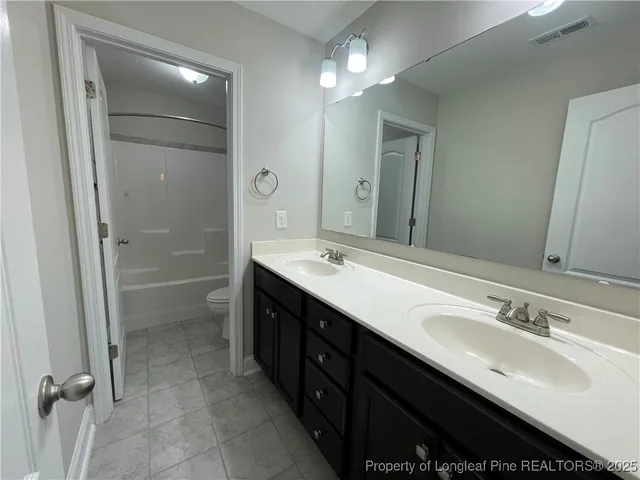 a bathroom with a double vanity sink mirror and shower