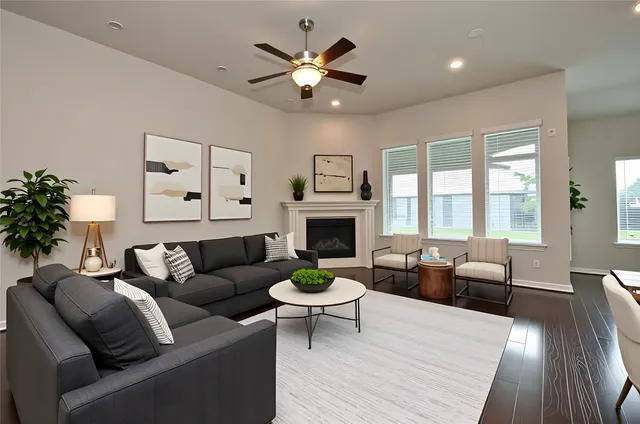 a living room with furniture a fireplace and a large window