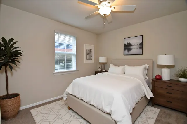 a bedroom with a large bed and a potted plant