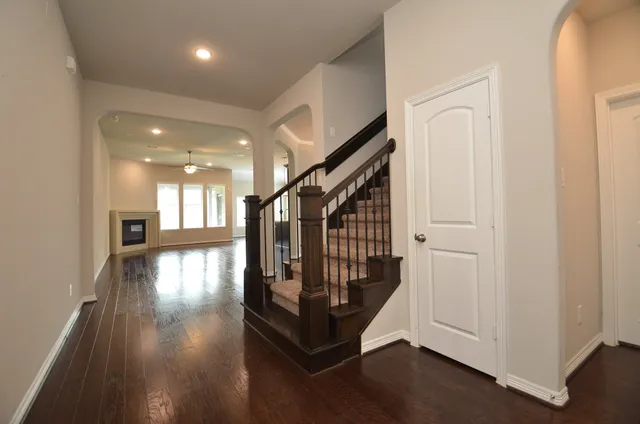 a view of a hallway with wooden floor and stairs