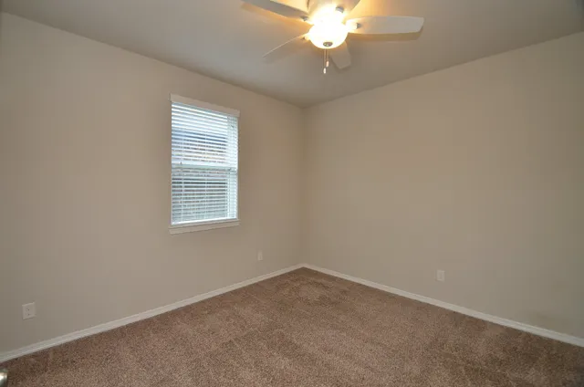 an empty room with a chandelier fan