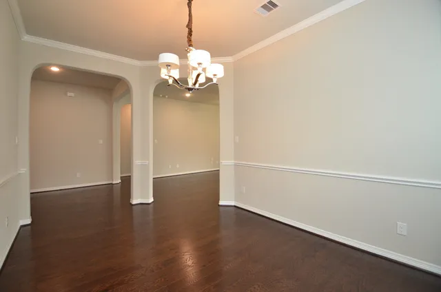a view of a room with wooden floor and chandelier