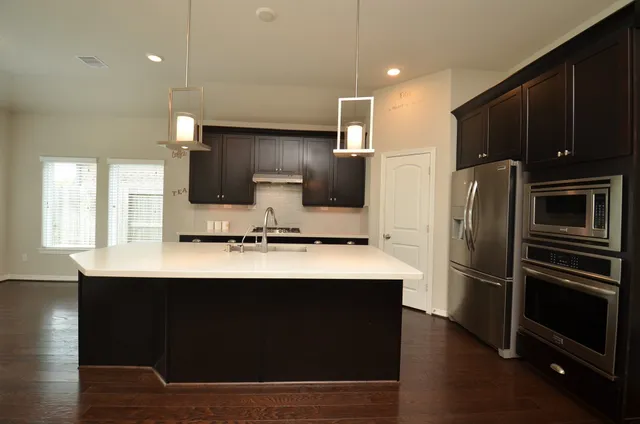 a kitchen with stainless steel appliances a sink stove refrigerator and cabinets