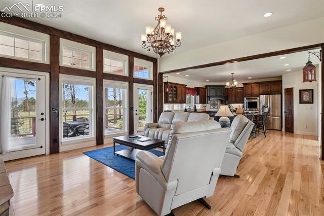 12810 Holmes Road Colorado Springs, CO 80908 - Photo 2 of 45 Living room featuring light hardwood / wood-style flooring and an inviting chandelier