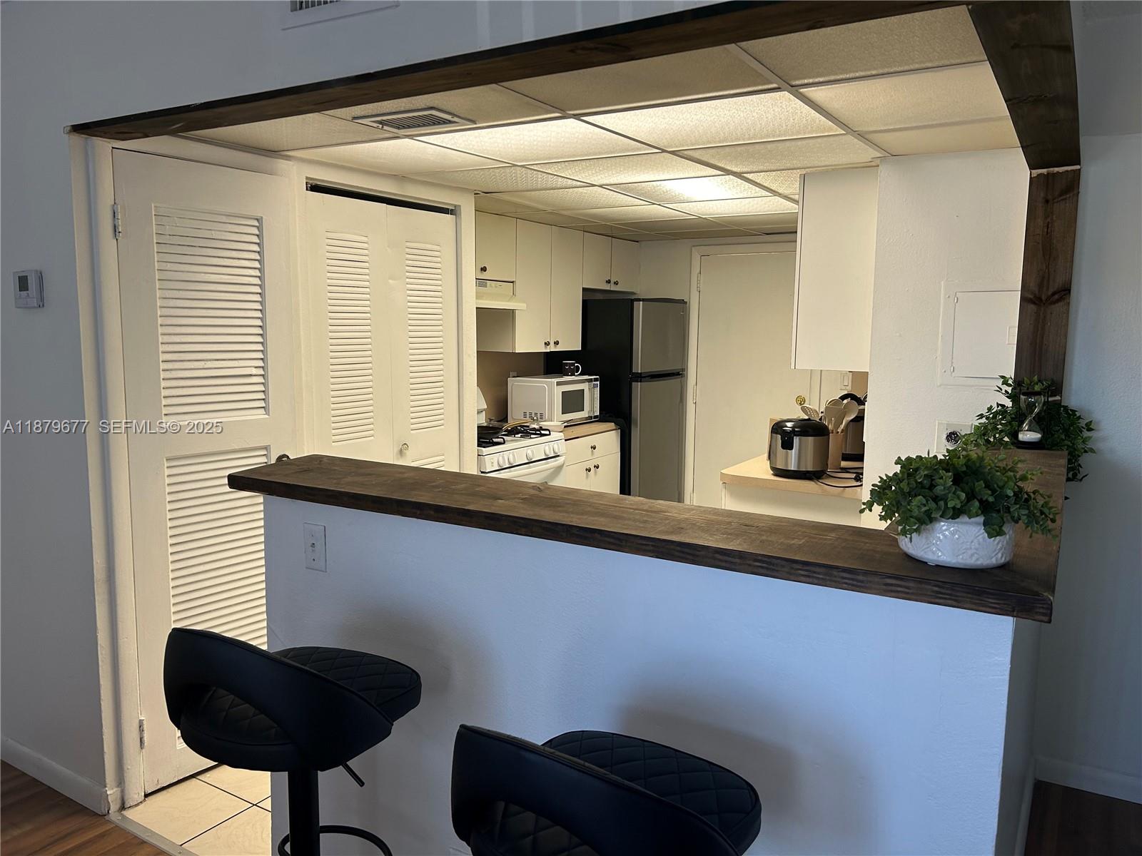 17901 Northwest 68th Avenue, Unit R209 Hialeah, FL 33015 - Photo 1 of 40 a kitchen with a sink and a potted plant