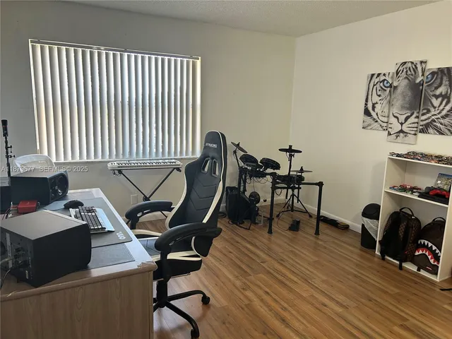 a view of a workspace with furniture and a window