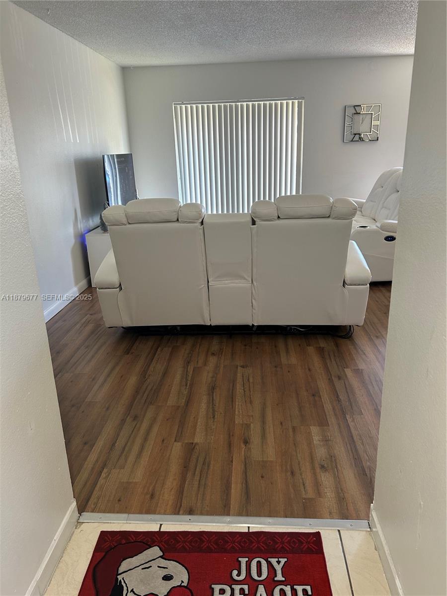 17901 Northwest 68th Avenue, Unit R209 Hialeah, FL 33015 - Photo 2 of 40 a living room with a wooden floor