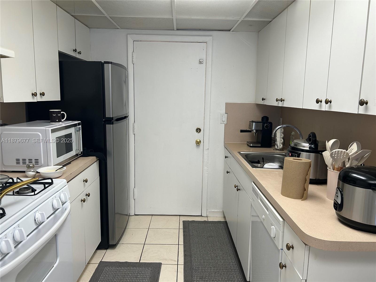 17901 Northwest 68th Avenue, Unit R209 Hialeah, FL 33015 - Photo 8 of 40 a kitchen with a sink and a stove top oven