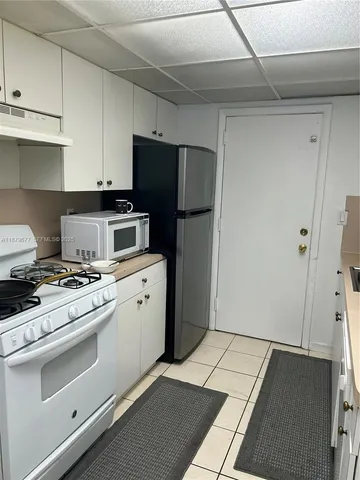 a kitchen with a stove top oven and refrigerator